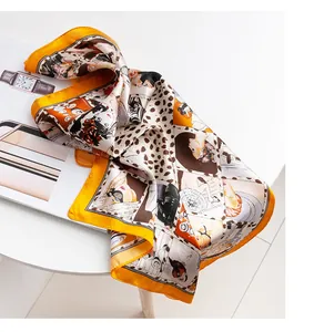 Detailed view of luxury orange silk square scarf with leopard and character print