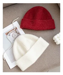 Close-up detail of red and white premium wool knit beanies showing high-quality texture