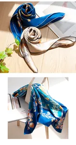 Close-up detail of blue silk scarf featuring elegant prints and hand-rolled edges