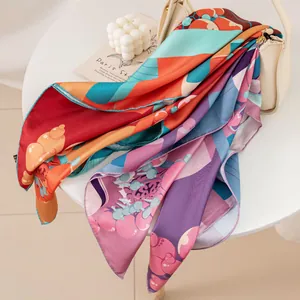 Luxurious artistic pear garden print silk square scarf draped on a cream handbag