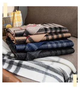 Detailed macro view of high-quality wool scarves featuring classic multi-color plaid patterns.