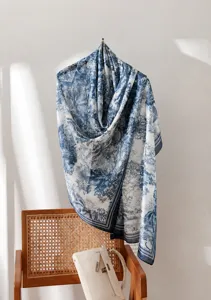Détail d'une écharpe en soie imprimée Toile de Jouy bleue et blanche sur une chaise