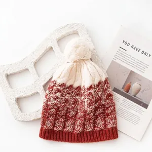 100% wool knit pom-pom beanie in cream and rust red with thick warm texture.