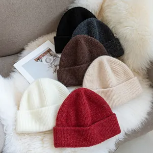 Premium winter cuffed beanies made of 93% wool in six colors on white faux fur background