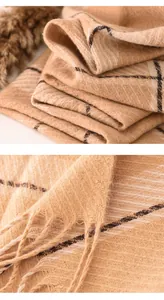 Close-up of the thick fabric texture and delicate fringe of this cozy checkered winter scarf
