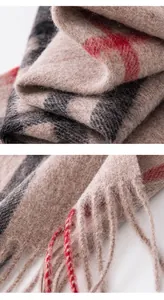 Close-up macro view showing the soft wool texture and fringed tassels of this plaid scarf