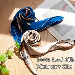 Two rolled 100% mulberry silk scarves with elegant patterns on a wooden surface