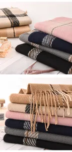 Close-up detail of soft stacked thick plaid scarves with elegant fringes in autumn colors