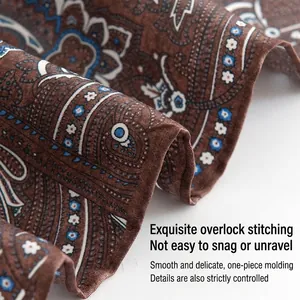 Detailed macro shot of a paisley pattern silk square scarf showing fine hem quality