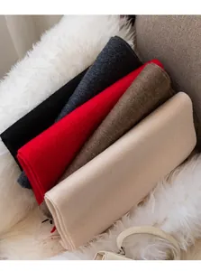 Vue détaillée d'écharpes en cachemire de couleur unie pliées sur une fausse fourrure.