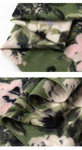 Dettaglio ravvicinato della morbida texture di una sciarpa floreale verde in cashmere