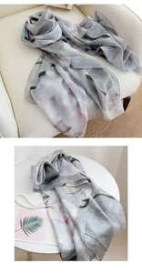 Detailed macro view of ink-wash magnolia print on a soft mulberry silk scarf