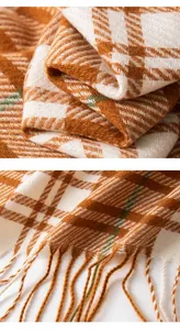 Detail van een oranje geblokte sjaal met zachte franjes