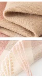 Makrodetail eines rosa karierten Lammwollschals mit weicher Textur und Fransen.