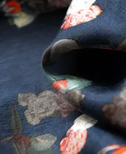 Close-up detail of navy blue mulberry silk scarf with vibrant floral pattern