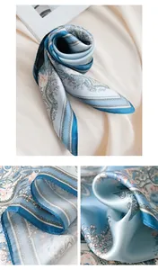 Macro detail view of a premium blue mulberry silk square scarf with paisley floral patterns.