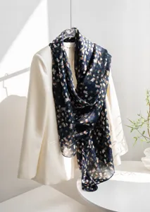 Detailed view of navy blue floral mulberry silk scarf draped over a white blazer
