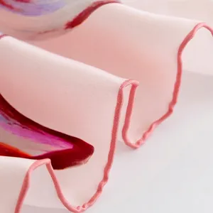 Detailed close-up showing the professional overlock stitching on an elegant pink silk scarf