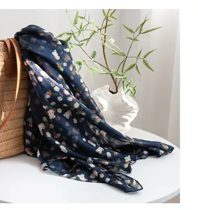 Detailed view of a navy blue mulberry silk scarf with small floral pattern and soft drape.