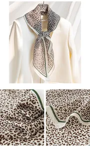 Detailed view of elegant leopard print silk wool scarf with green and white border