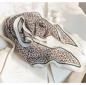 Macro view of leopard print silk scarf texture with elegant white and green borders