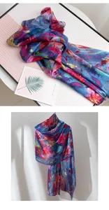Macro view of a lightweight mulberry silk scarf with vibrant blue and red floral patterns