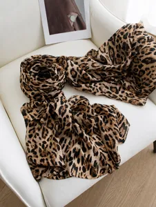 Detailed view of 100% mulberry silk scarf with leopard print on a white chair