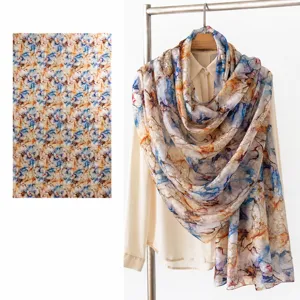 Detailed macro view of a luxurious mulberry silk scarf featuring blue and orange abstract prints