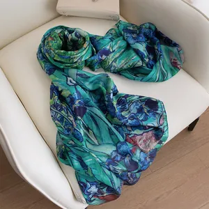 Premium blue and green iris flower printed mulberry silk long scarf displayed on white chair