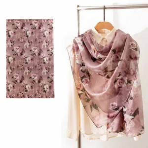 Detailed view of elegant pink floral mulberry silk scarf on a white shirt.