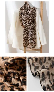 Close-up detail of luxurious leopard print silk scarf fabric and draped styling
