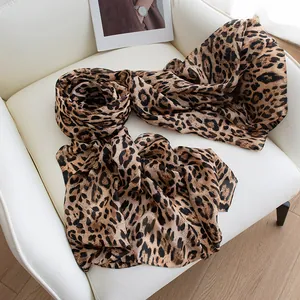 Elegant and breathable mulberry silk leopard print long scarf for women draped on a chair