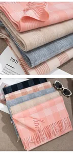 Macro detail of stacked 100% wool plaid scarves in soft pastel colors with fringe