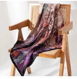 Detailed view of luxury silk scarf with artistic oil painting print draped on chair
