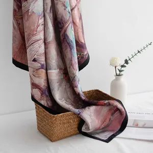 Elegant mulberry silk scarf with artistic oil painting print draped over a woven basket.