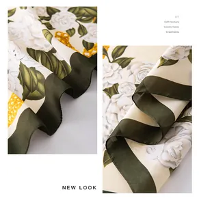 Close-up of floral print imitation silk scarf with green border and soft texture
