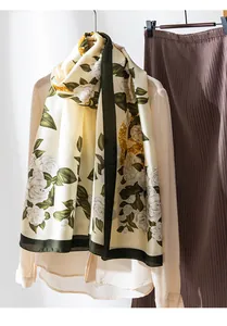 Close-up detail of a cream silk-like scarf featuring elegant white camellia floral prints.
