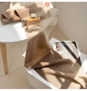 Nahaufnahme eines Wollschals im Maillard-Stil mit weicher Stricktextur in Brauntönen