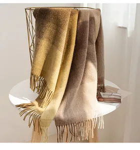 Detailaufnahme eines Wollschals mit Quasten in warmen Farbtönen im Maillard-Stil