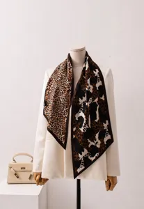 Detalle de un pañuelo de seda con estampado de leopardo sobre blazer blanco.