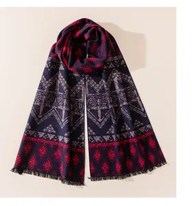Close-up detail of a premium brushed silk scarf featuring red and navy ethnic geometric patterns