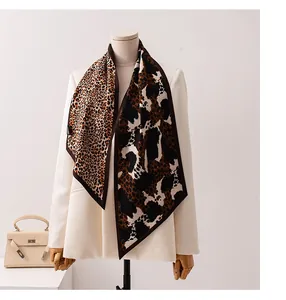 Detail shot of a stylish leopard and cow print silk wool scarf on a white blazer.