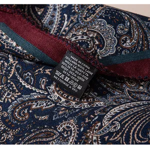 Detalle de la etiqueta de cuidado de una bufanda de mezcla de seda y lana con estampado paisley