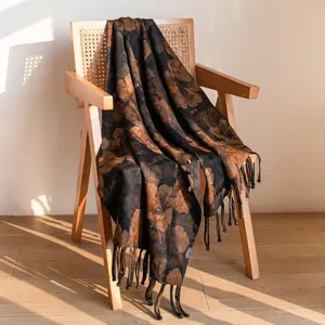 Elegante scialle di seta a doppio strato con stampa floreale e nappe su sedia in legno