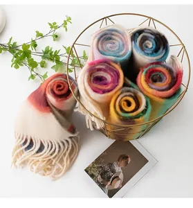 Detailed view of rolled mohair scarves with rainbow colors in a gold wire basket