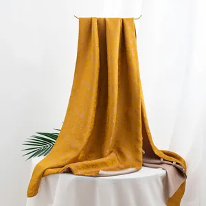 Luxuriöser seidenschal in senfgelb mit floralem jacquard-muster im studio-ambiente