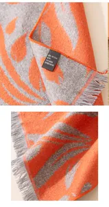 Detailed macro shot of 100% mulberry silk scarf featuring orange leaf pattern and grey fringe