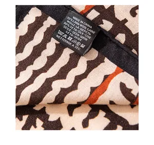 Close-up of wash care label on a retro wool and silk blend patterned shawl scarf