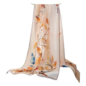 Elegant mulberry silk scarf featuring a vibrant autumn leaf print on a clean white background