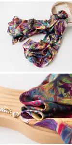 Close-up detail of luxurious mulberry silk scarf with colorful phoenix feather print pattern